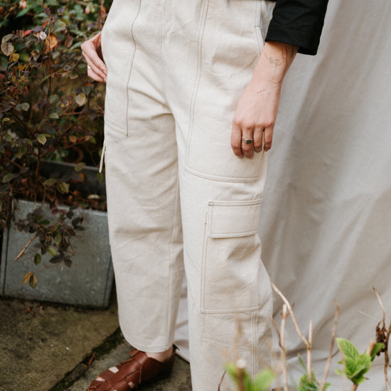 Person wearing beige cargo pants and brown shoes outdoors.
