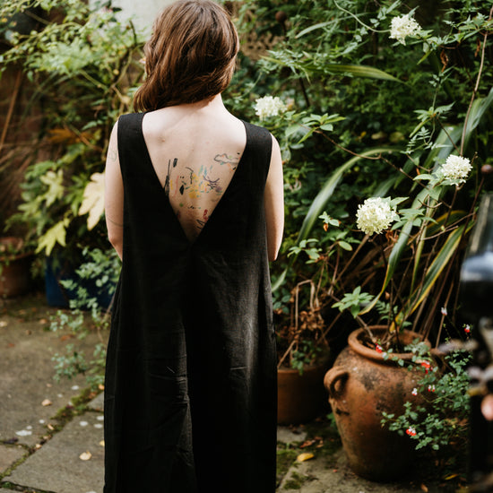 woman wearing a long black linen dress in a garden setting