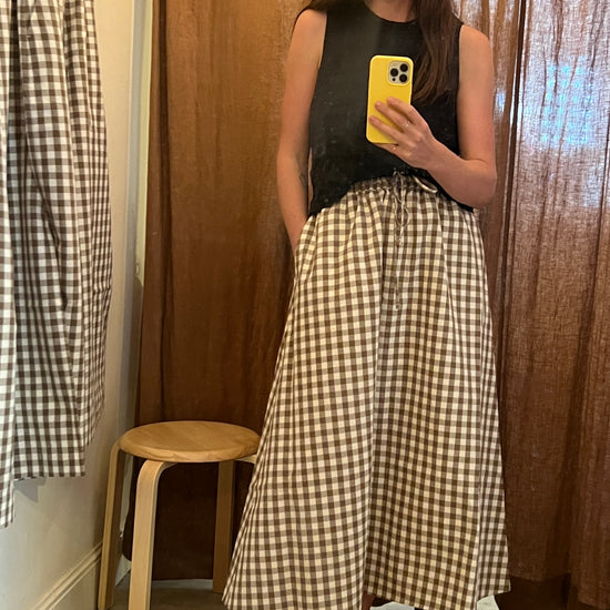 model wearing black top and atwin the label brown gingham a-line skirt