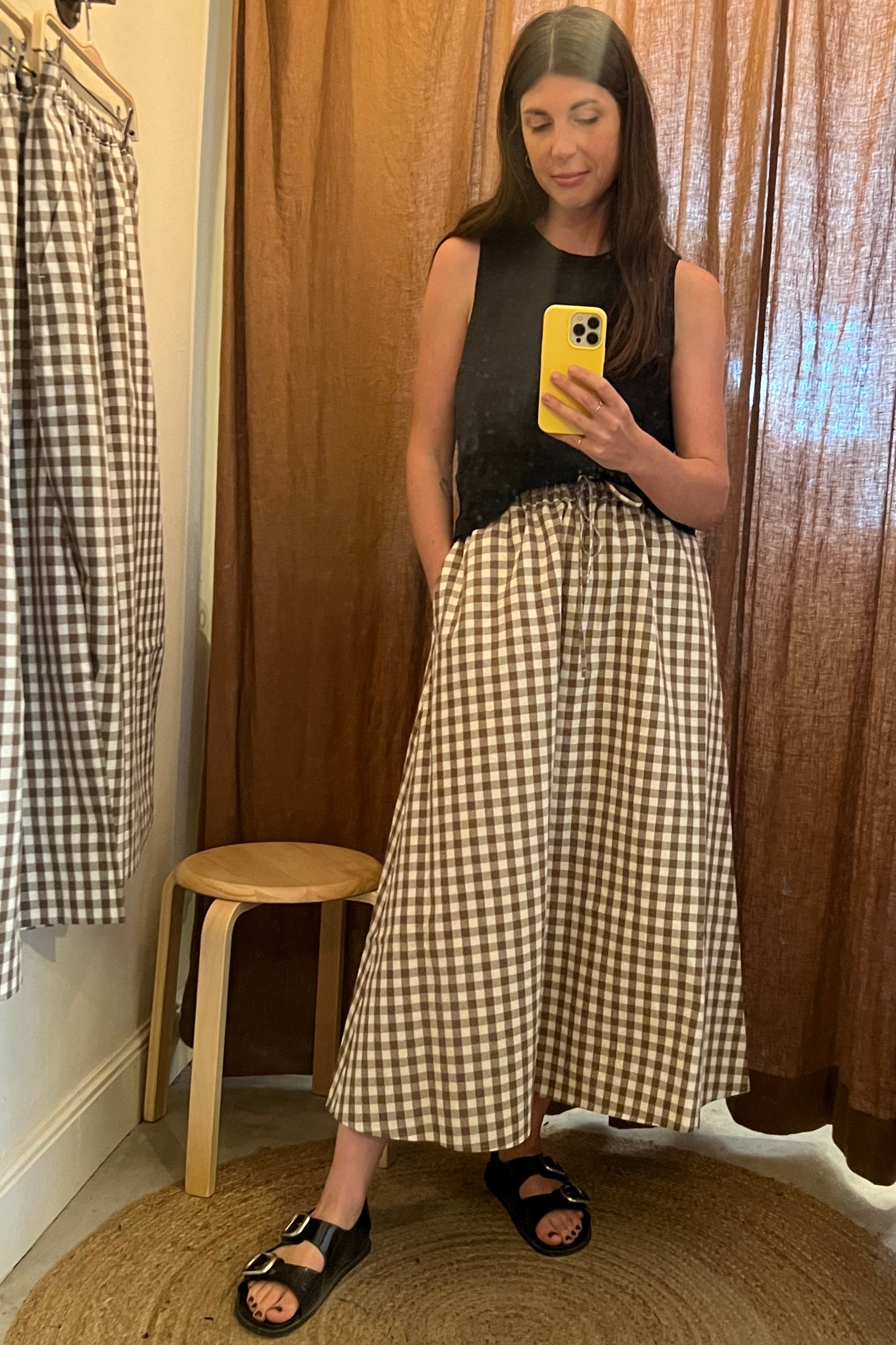 model wearing black top and atwin the label brown gingham a-line skirt