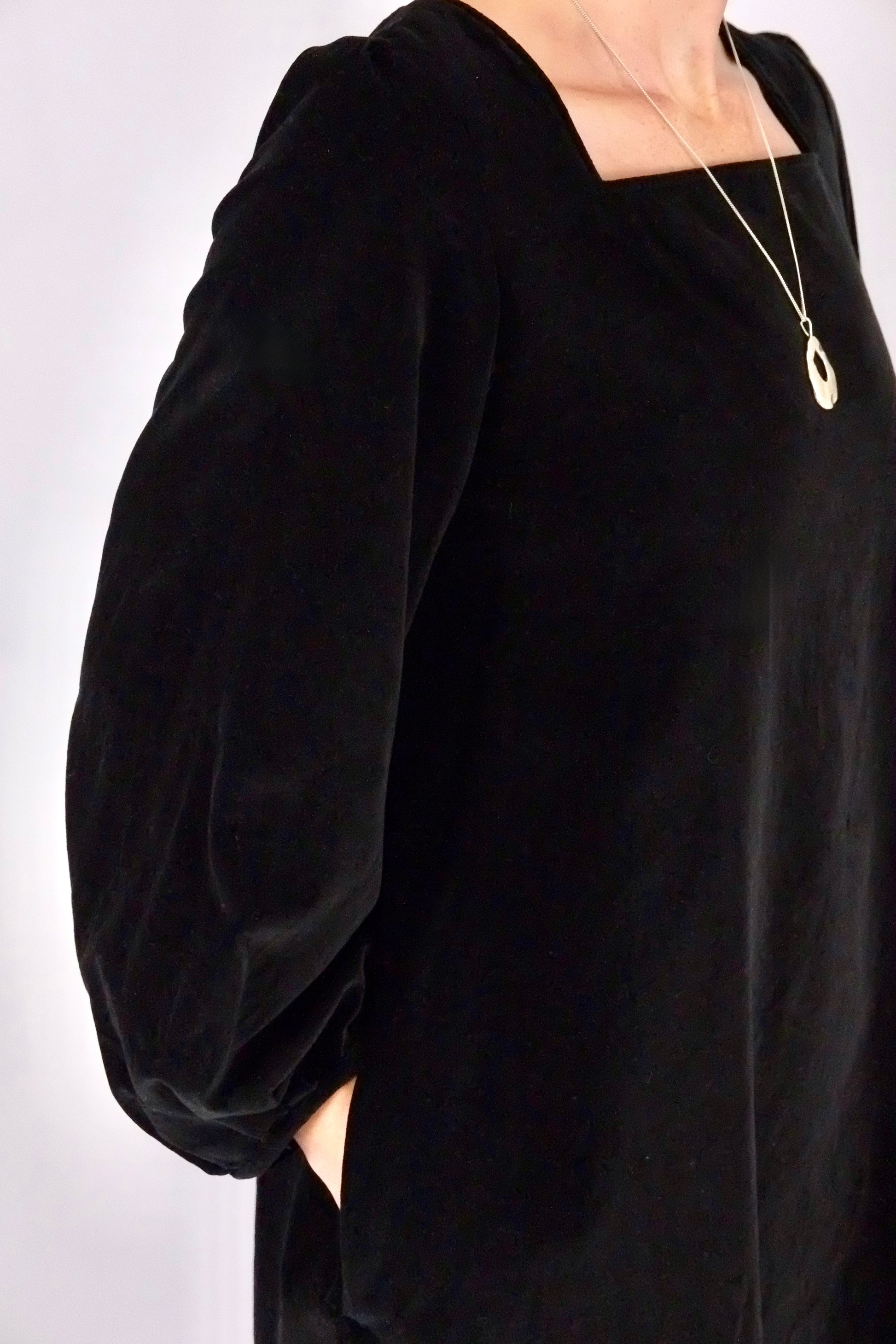 Black velvet dress with puffed sleeves on a white background