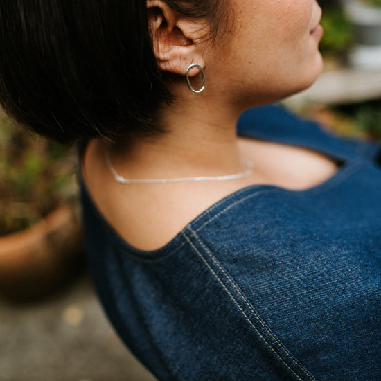 Close-up of a person wearing a blue denim top with a blurred background