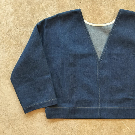 Blue denim top on a beige surface