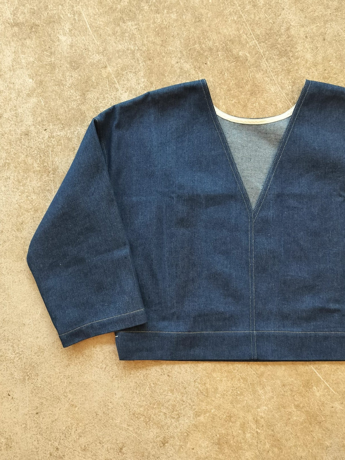 Blue denim top on a beige surface