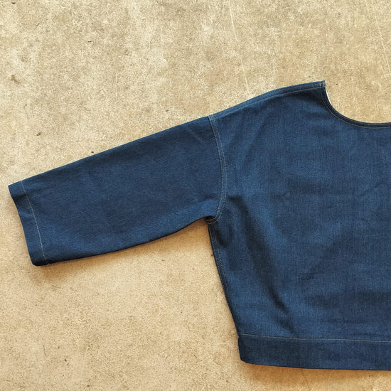 Blue denim top on a beige surface