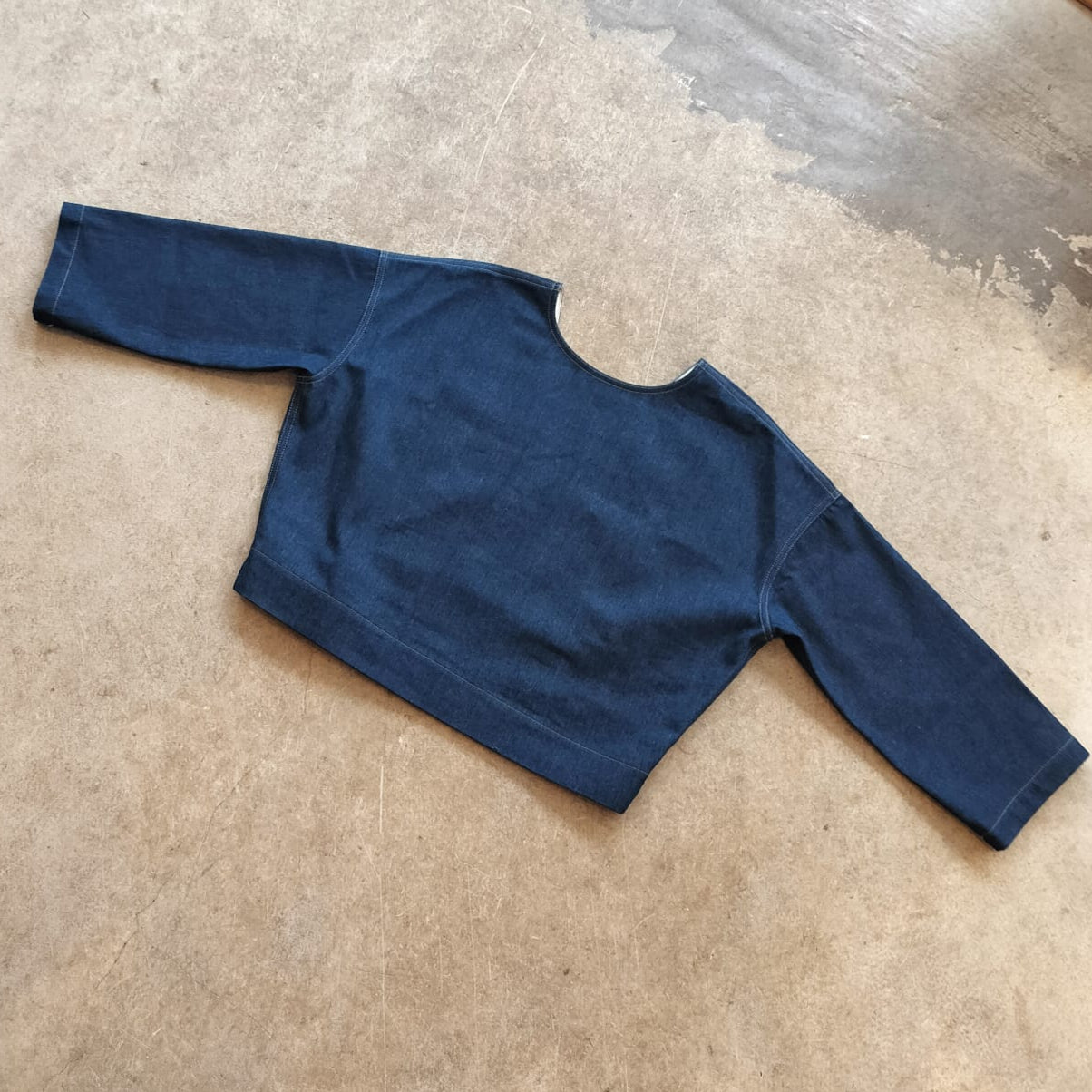 Blue long-sleeve top on a beige background