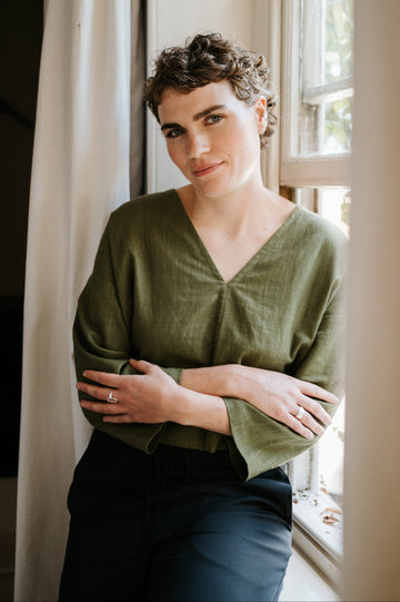 woman sitting on windowsill wearing atwin the label reversible top in khaki ramie linen