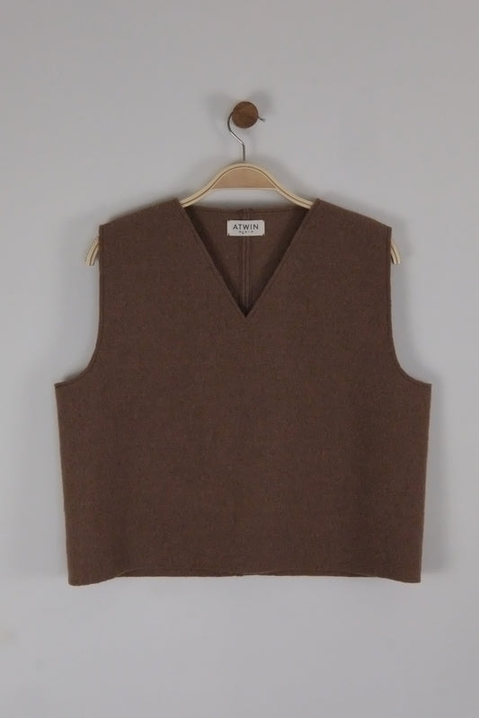 Brown boiled wool vest on a hanger against a light grey background