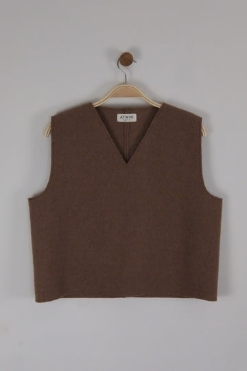 Brown boiled wool vest on a hanger against a light grey background