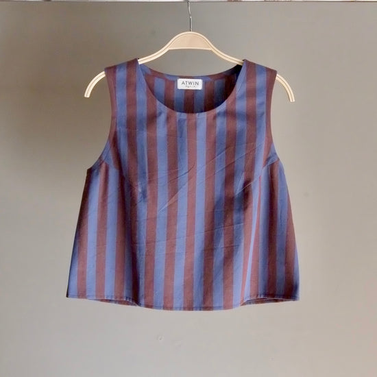 Striped sleeveless top on a hanger against a plain background