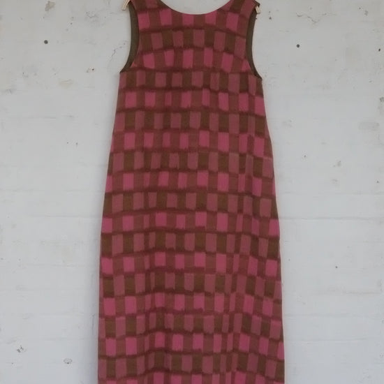 Red and brown checkered dress on a white surface