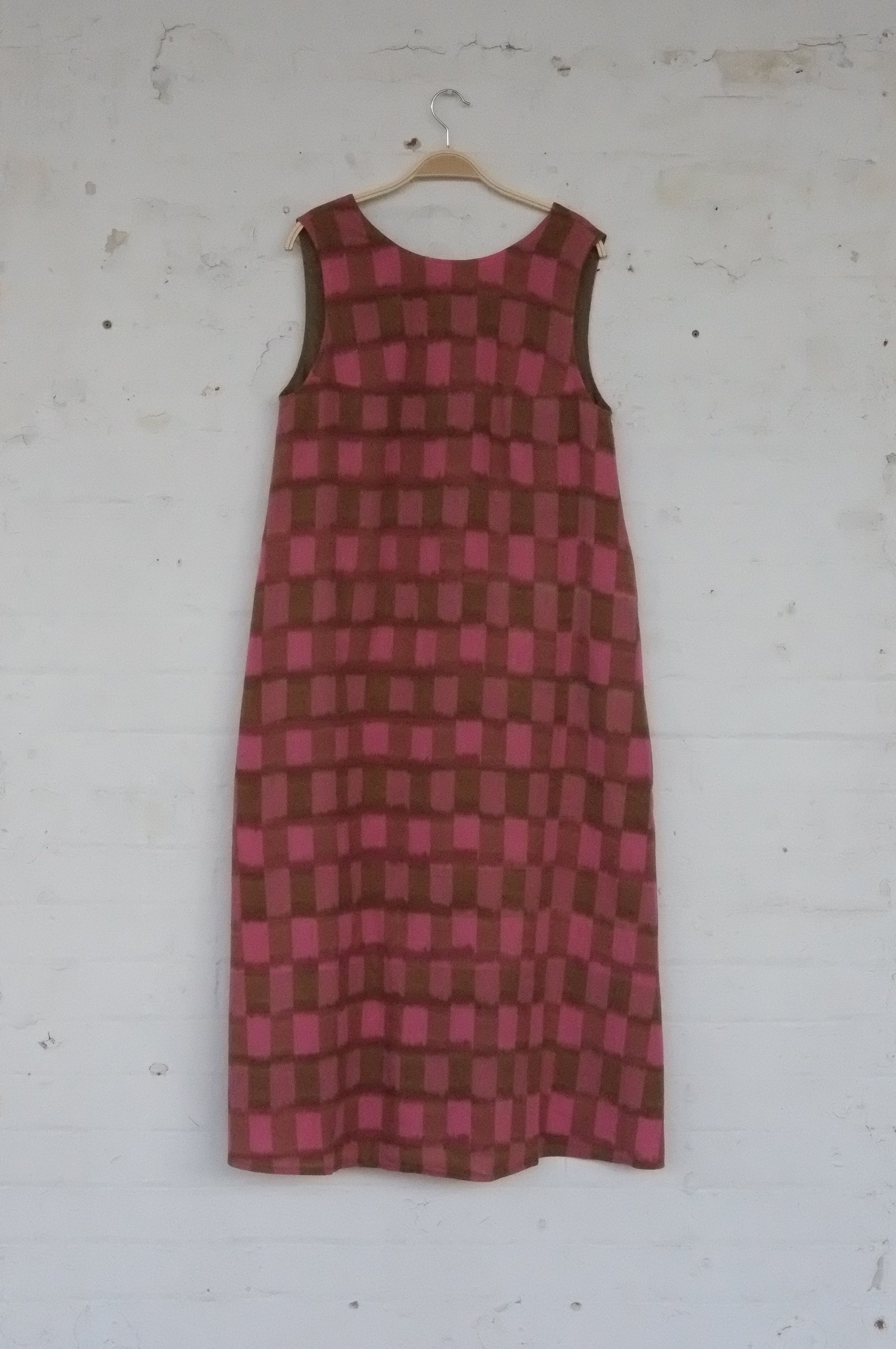 Red and brown checkered dress on a white surface