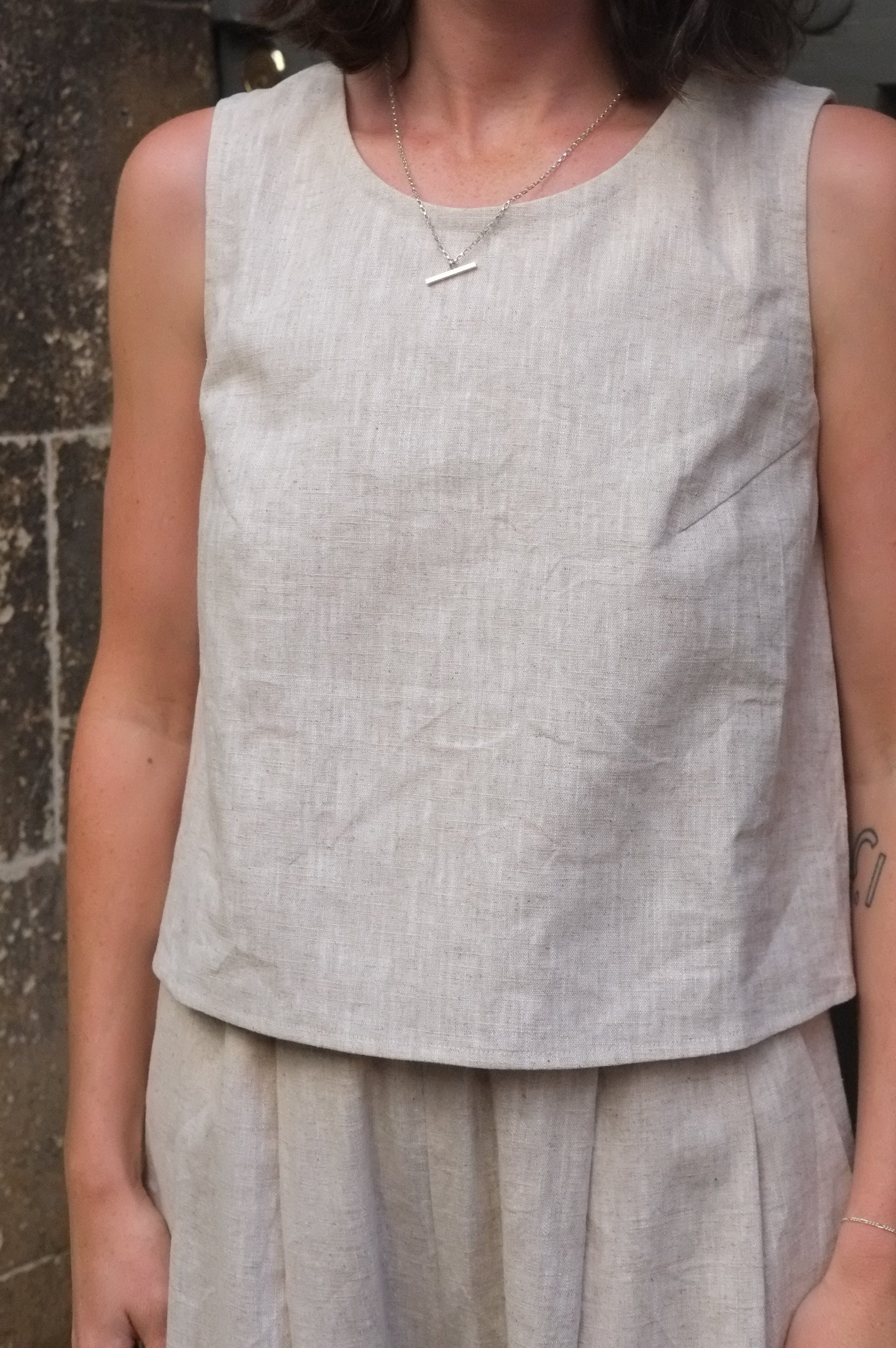 woman wearing a cream coloured sleeveless top 