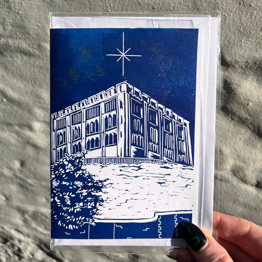 Greeting card with blue and white design of a building and star on a textured surface