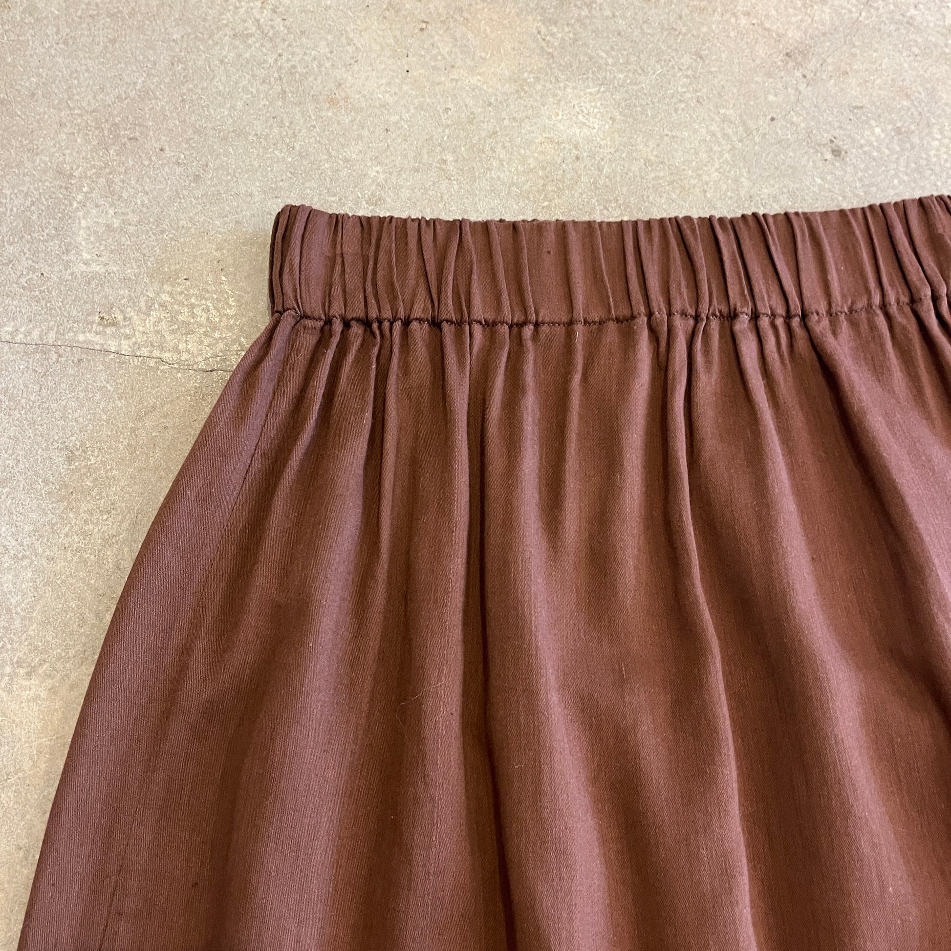 Brown skirt with an elastic waistband on a beige background