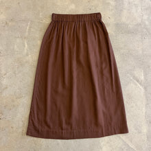 Load image into Gallery viewer, Brown skirt on a textured beige surface
