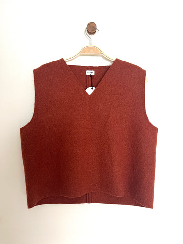 Rust colour wool boxy sleeveless tank top with a v-neck on a cream background