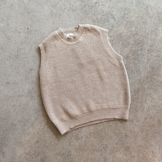 Beige knitted vest on a concrete surface