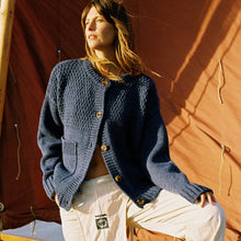 Load image into Gallery viewer, A woman in the sunlight wearing a blue wool cardigan 

