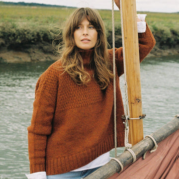 Woman wearing a burnt orange jumper on a boat