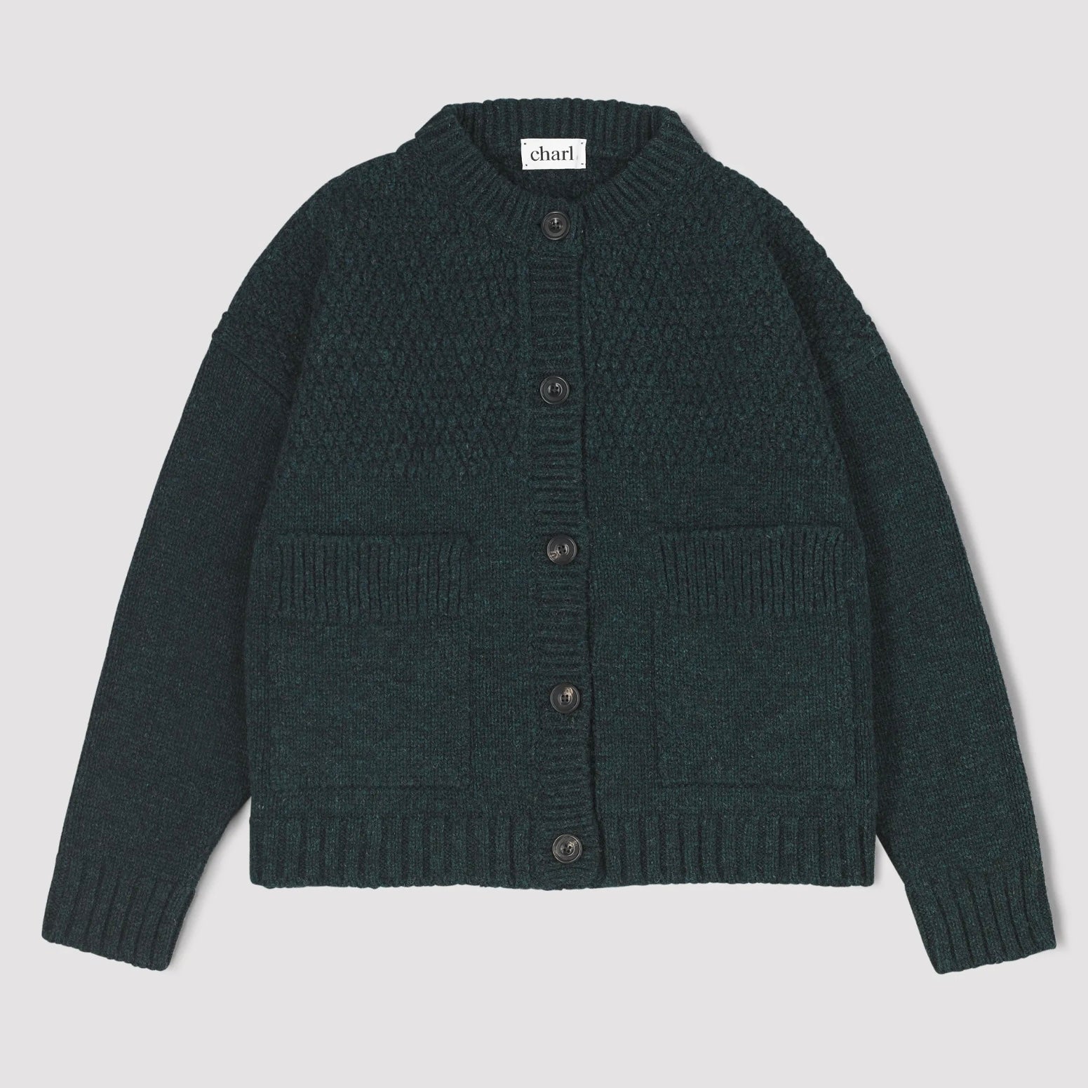 Dark green knitted cardigan with button details and square front pockets on a light grey background