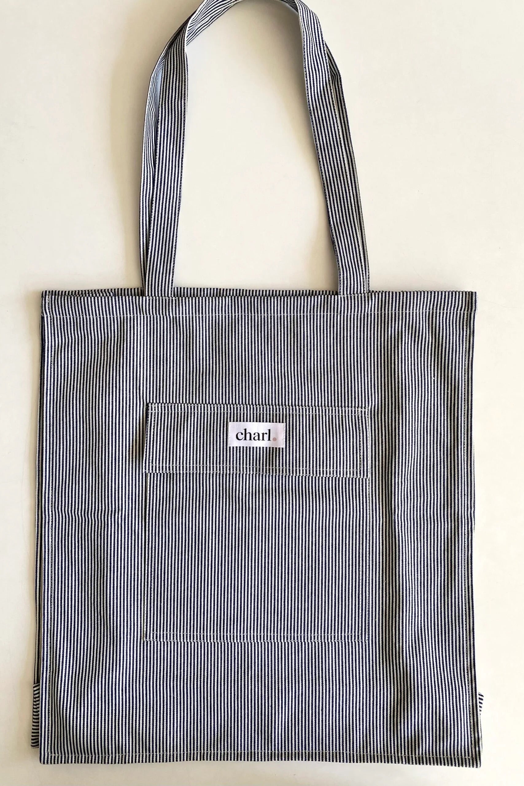 Blue striped tote bag with a visible brand logo on a light background