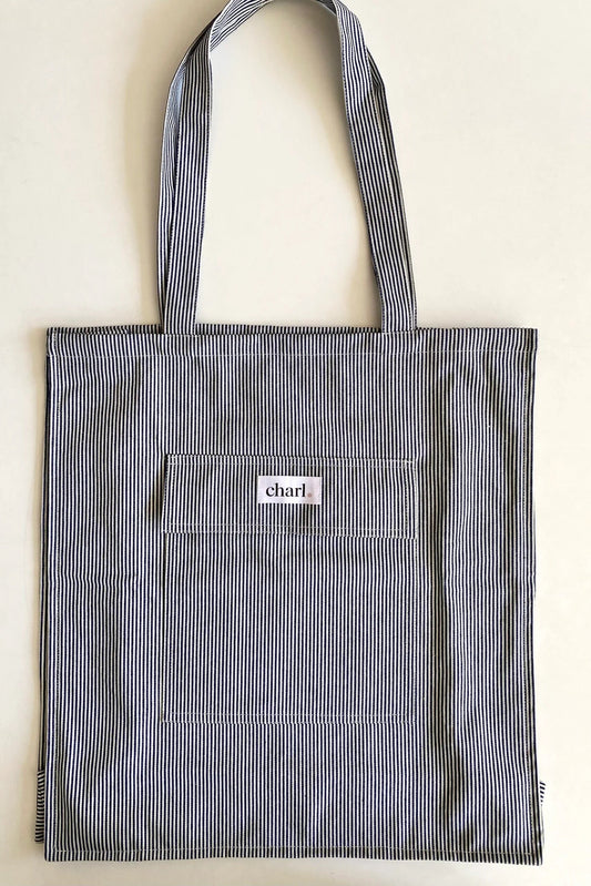 Blue striped tote bag with a visible brand logo on a light background