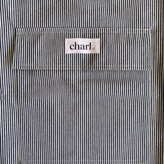 Close-up of a black and white striped bag with a 'charl' label on the pocket.