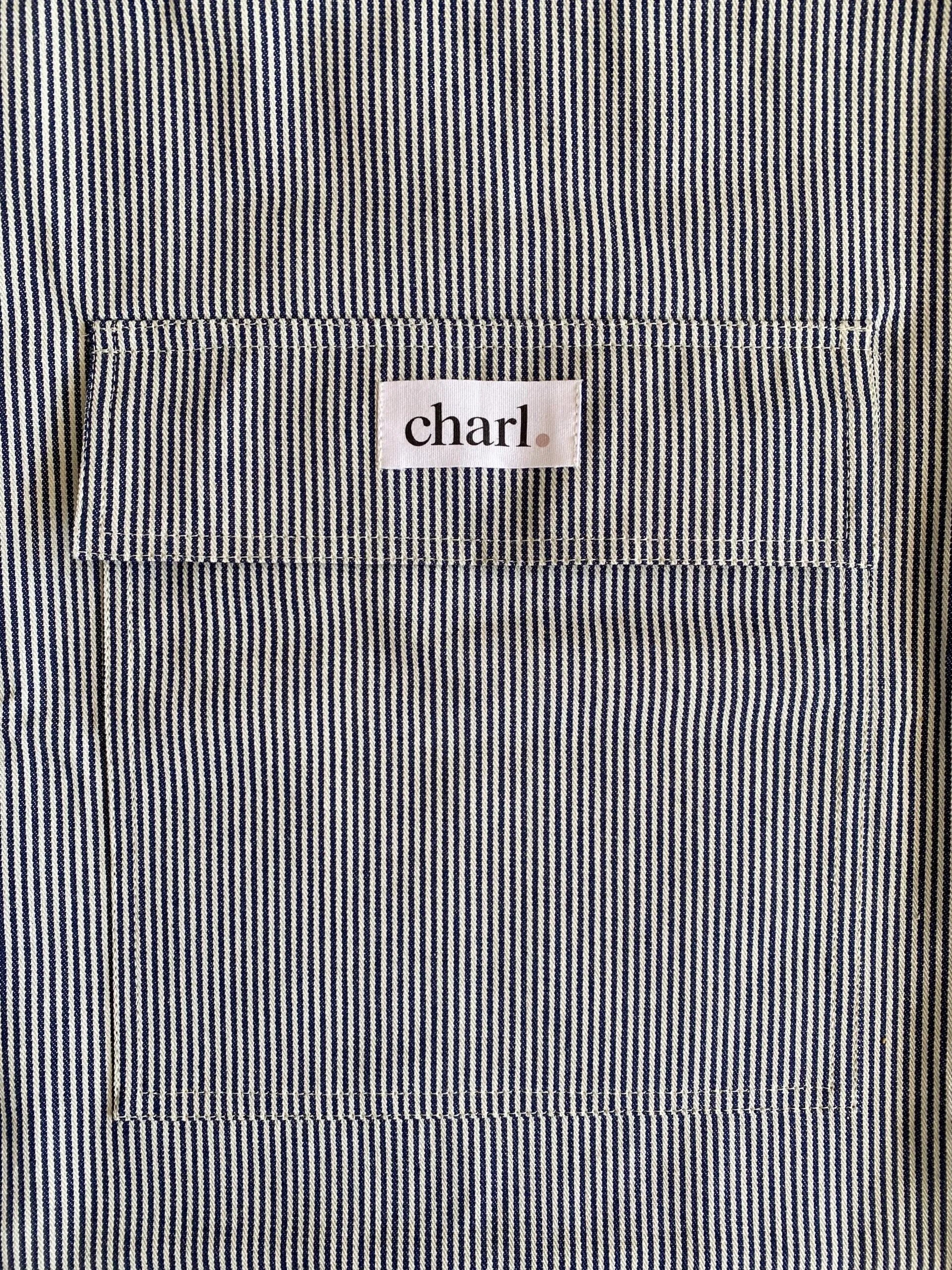Close-up of a black and white striped bag with a 'charl' label on the pocket.