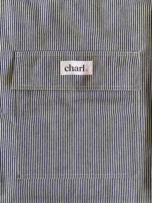 Close-up of a black and white striped bag with a 'charl' label on the pocket.