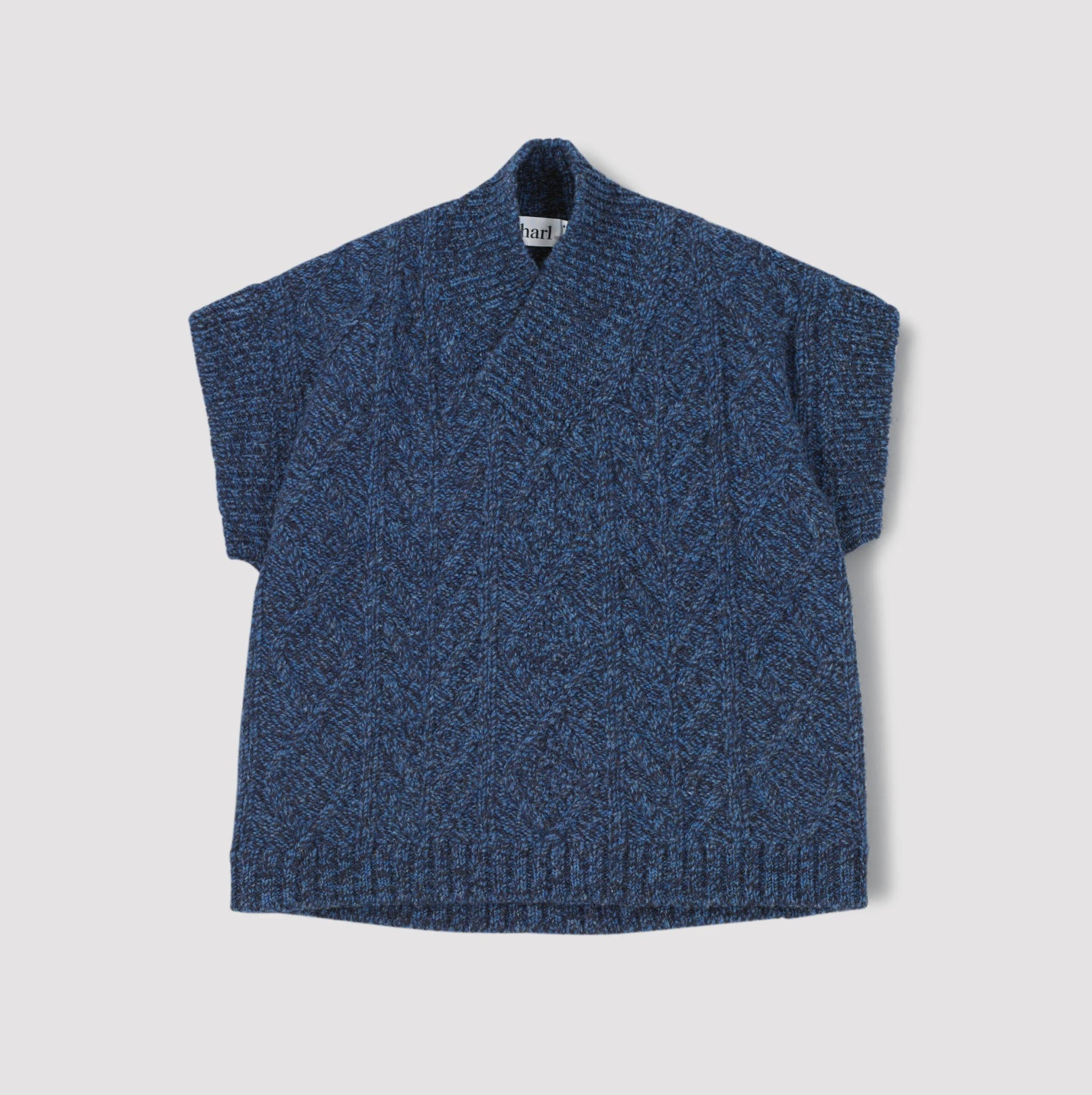 Blue knitted sleeveless sweater on a light grey background