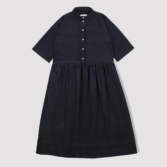 Navy corduroy dress with short sleeves and a button down front with a collar and gathered waist  on a light gray background