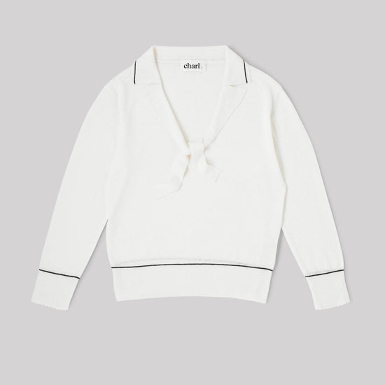 White top with blue trim on a gray background