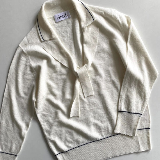 White  top with blue piping on a light gray background