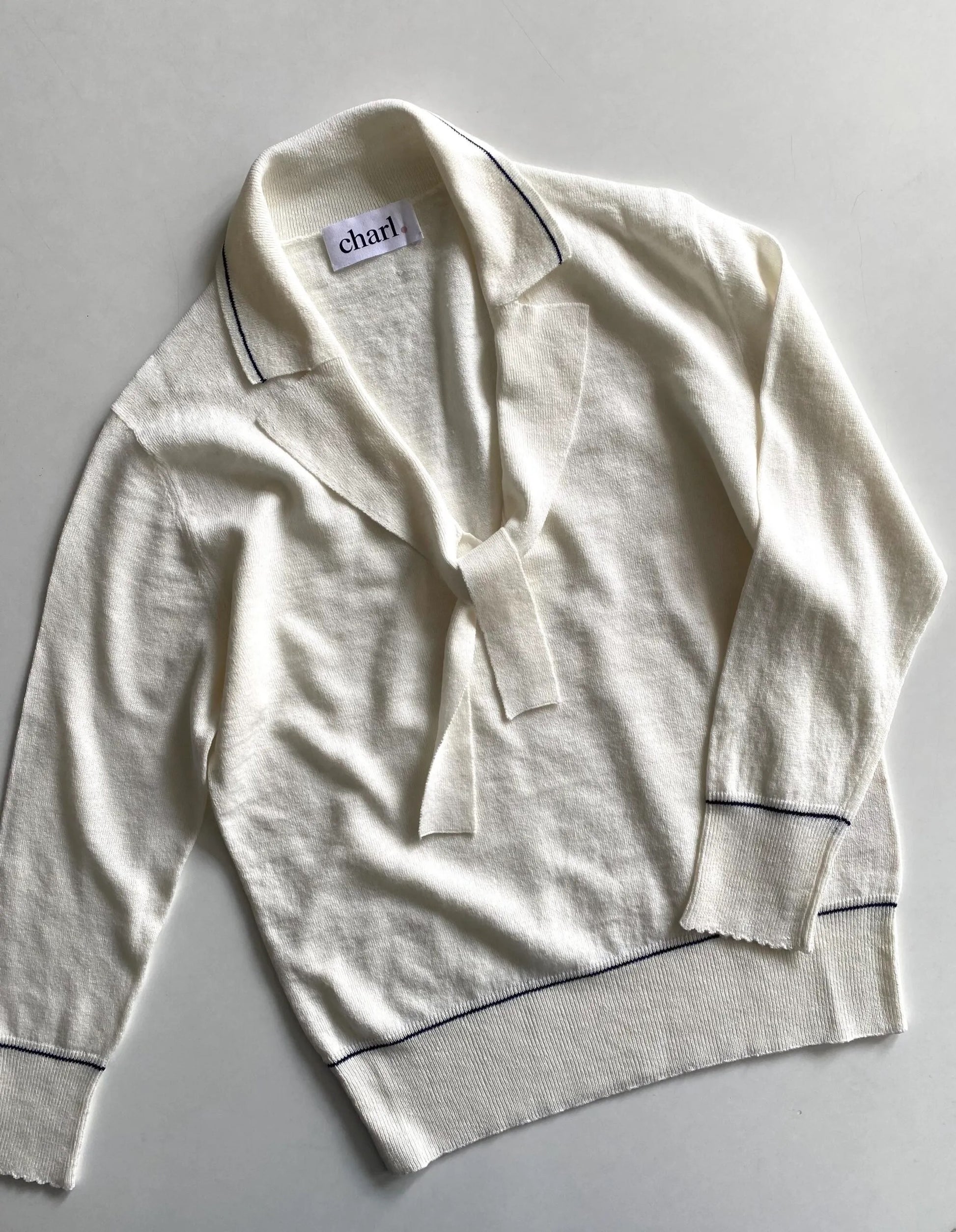White  top with blue piping on a light gray background