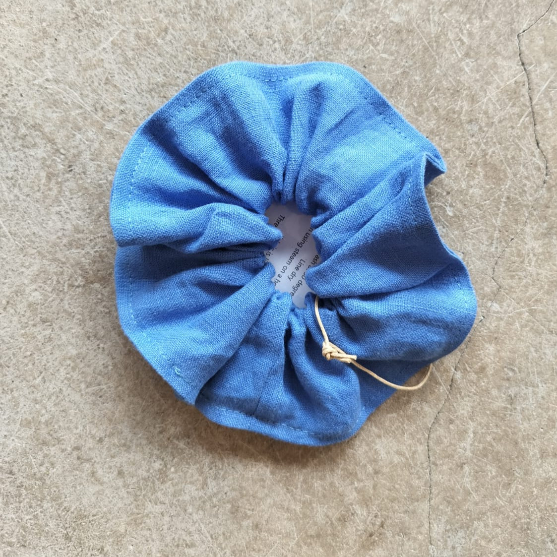 Blue scrunchie on a beige surface