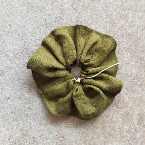 Green scrunchie on a textured gray surface