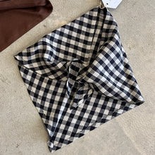 Load image into Gallery viewer, Black and white checkered neck tie scarf on a textured concrete surface
