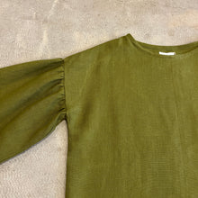 Load image into Gallery viewer, Green long-sleeve top on a textured beige surface
