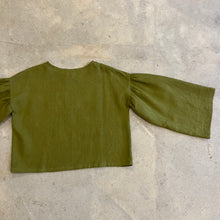 Load image into Gallery viewer, Green blouse with ruffled sleeves on a concrete floor

