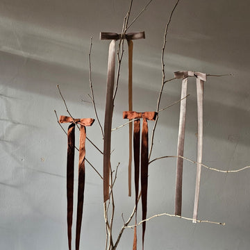 Silk bows on a tree branch with a neutral background 