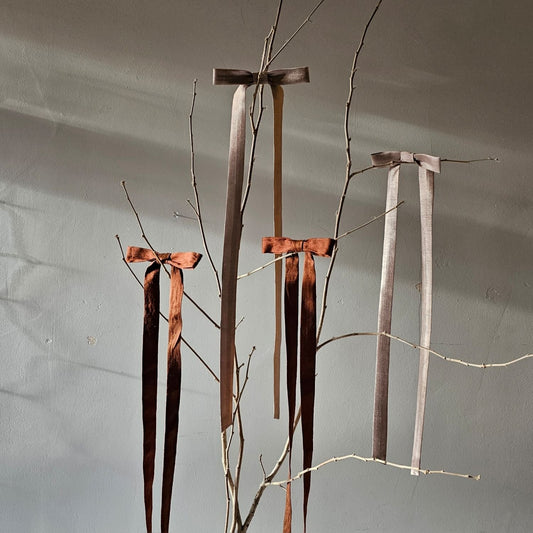 Silk bows on a tree branch with a neutral background 