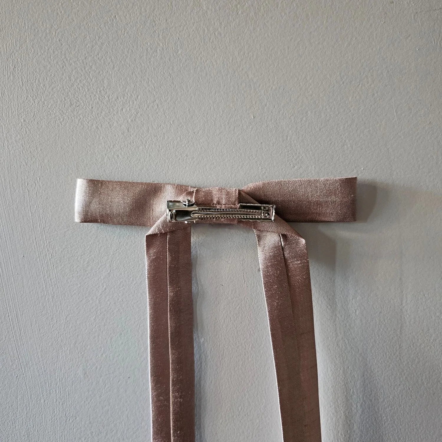 Brown velvet ribbon with a clip on a light gray background