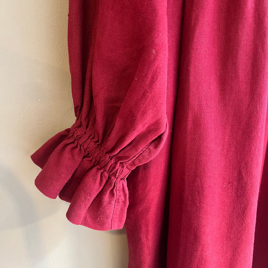 Close-up of a red garment with puffed sleeves on a neutral background