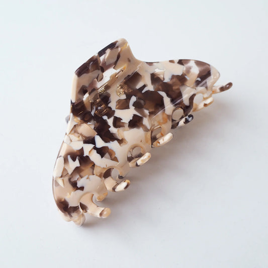 Pink and brown Tortoiseshell patterned hair clip on a white background