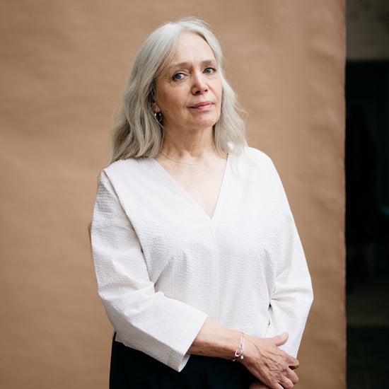 Woman wearing a white blouse against a brown background