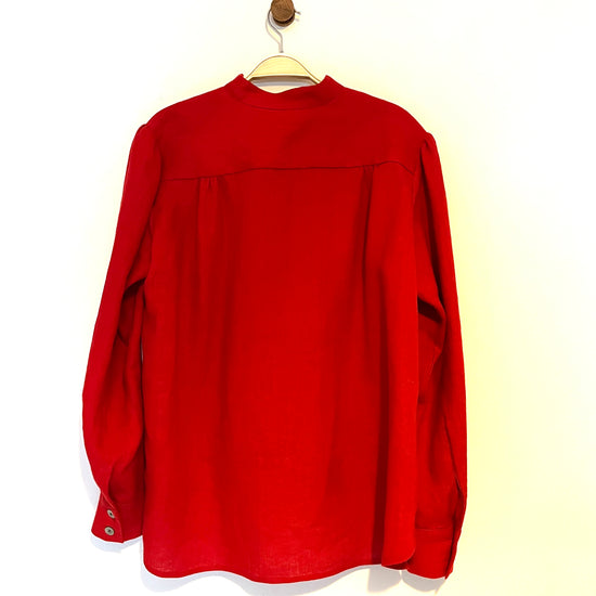 Red shirt on a hanger against a white background