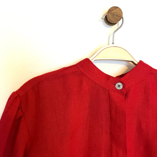 Red shirt on a hanger against a white background