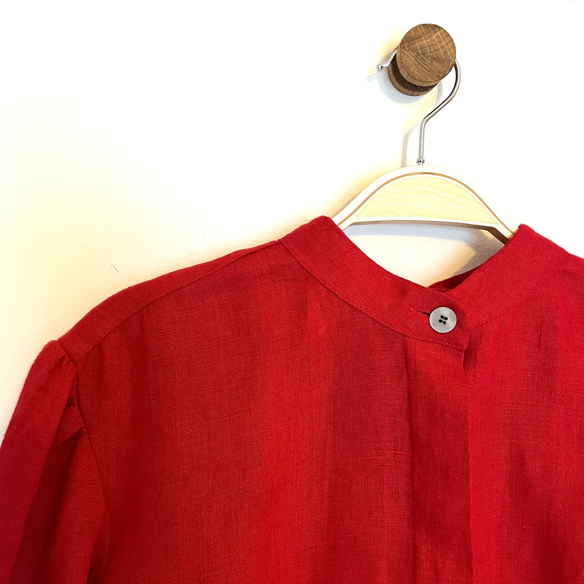 Red shirt on a hanger against a white background