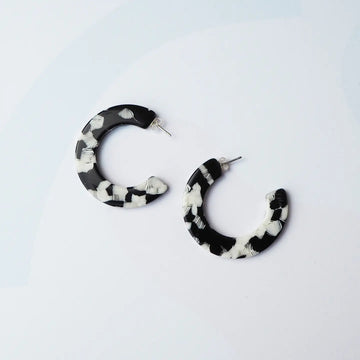 Black and white hoop earrings on a light grey background